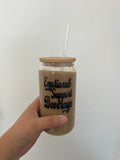 A glass tumbler with a bamboo lid that says emotional support beverage in black font
