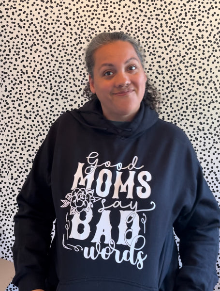 white text that says good moms say bad words on a black hoodie sweatshirt